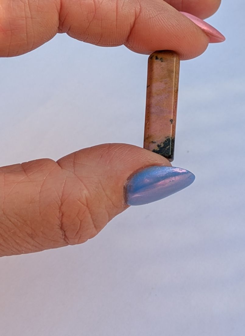 Affordable mini Rhodonite crystal showing pink and black veining